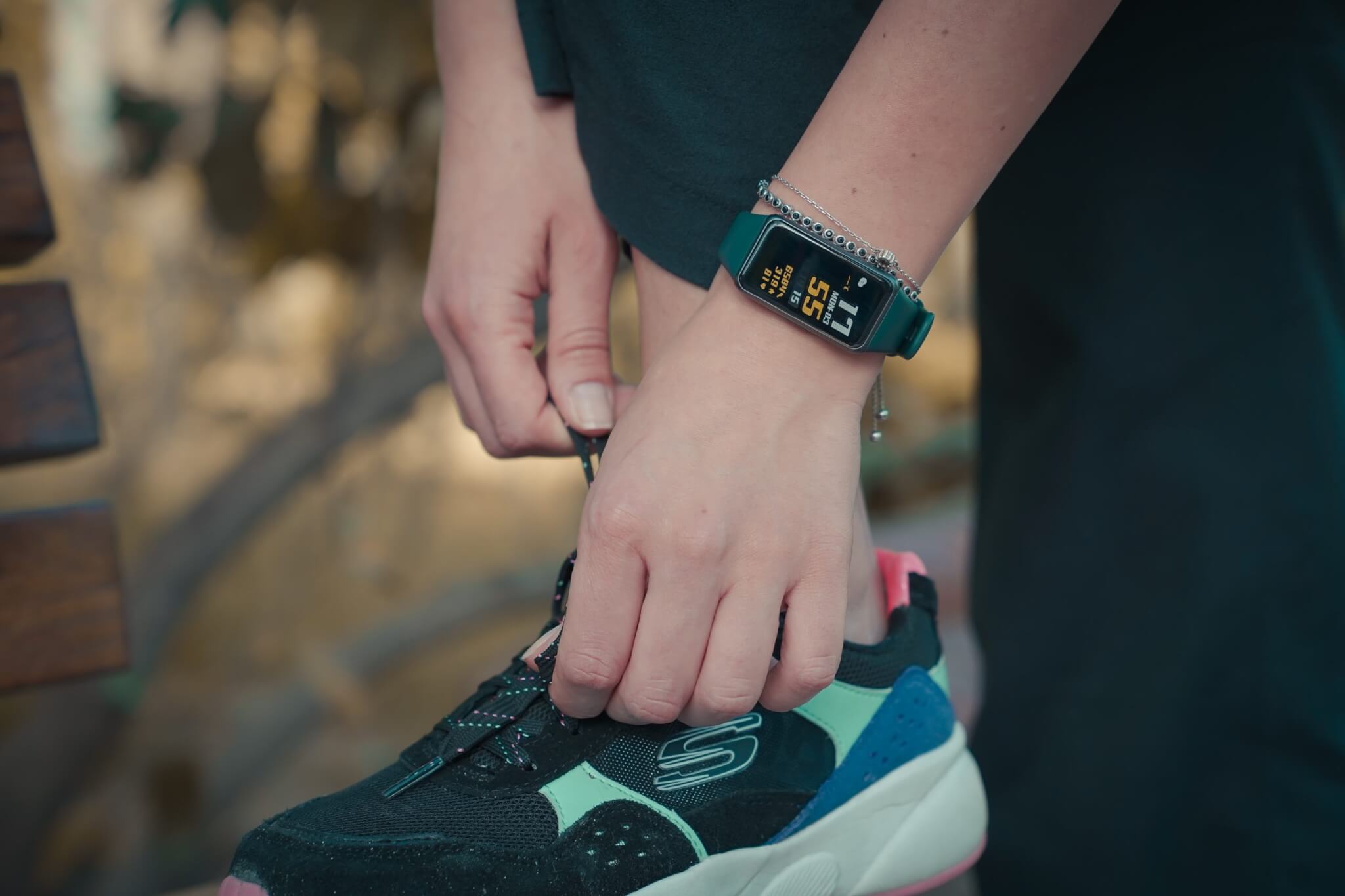 Runner lacing sneakers, wearing fitness tracker before exercising