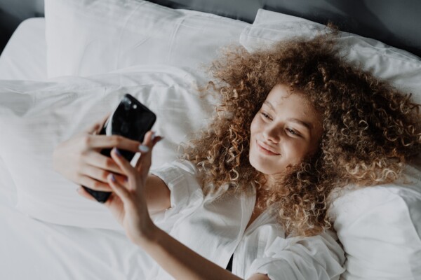 Woman taking selfie in bed