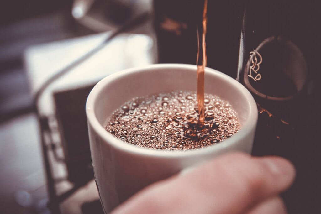 Coffee maker pouring fresh cup