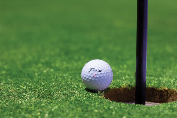Titleist golf ball on lip of cup