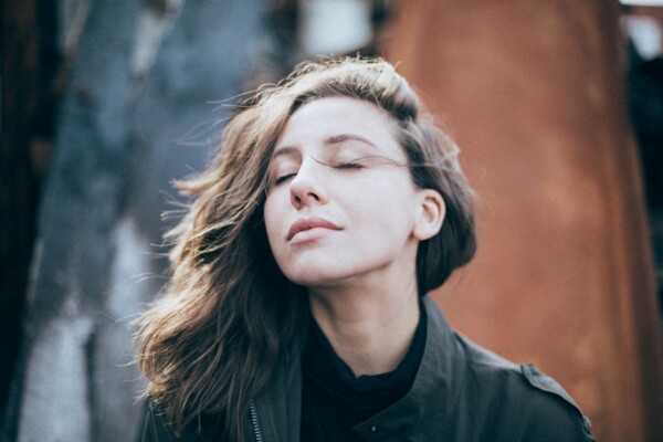 Woman taking a deep breath, closing her eyes
