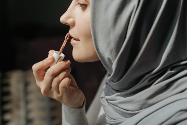 Woman putting on lip gloss