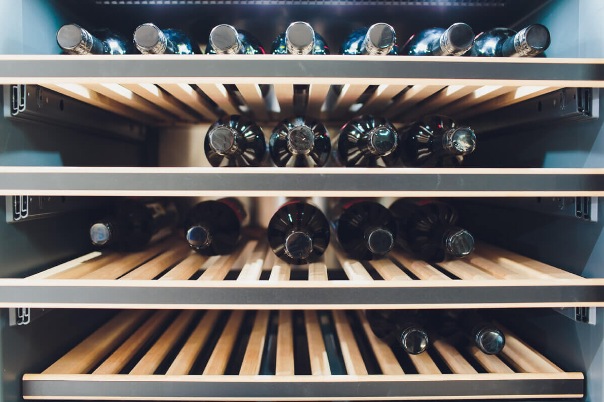 Storing bottles of wine in fridge. Alcoholic card in restaurant. Cooling and preserving wine.