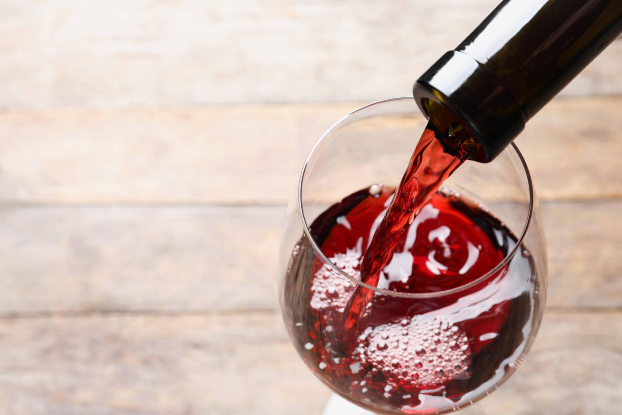 Pouring red wine from bottle into glass