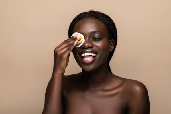 Woman using a makeup remover to clean her face.