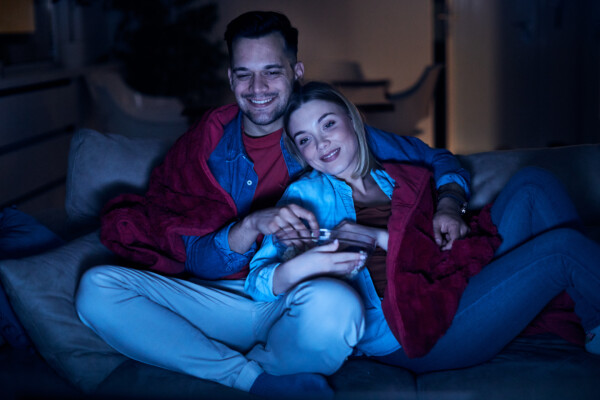Couple having movie night at home on the couch.