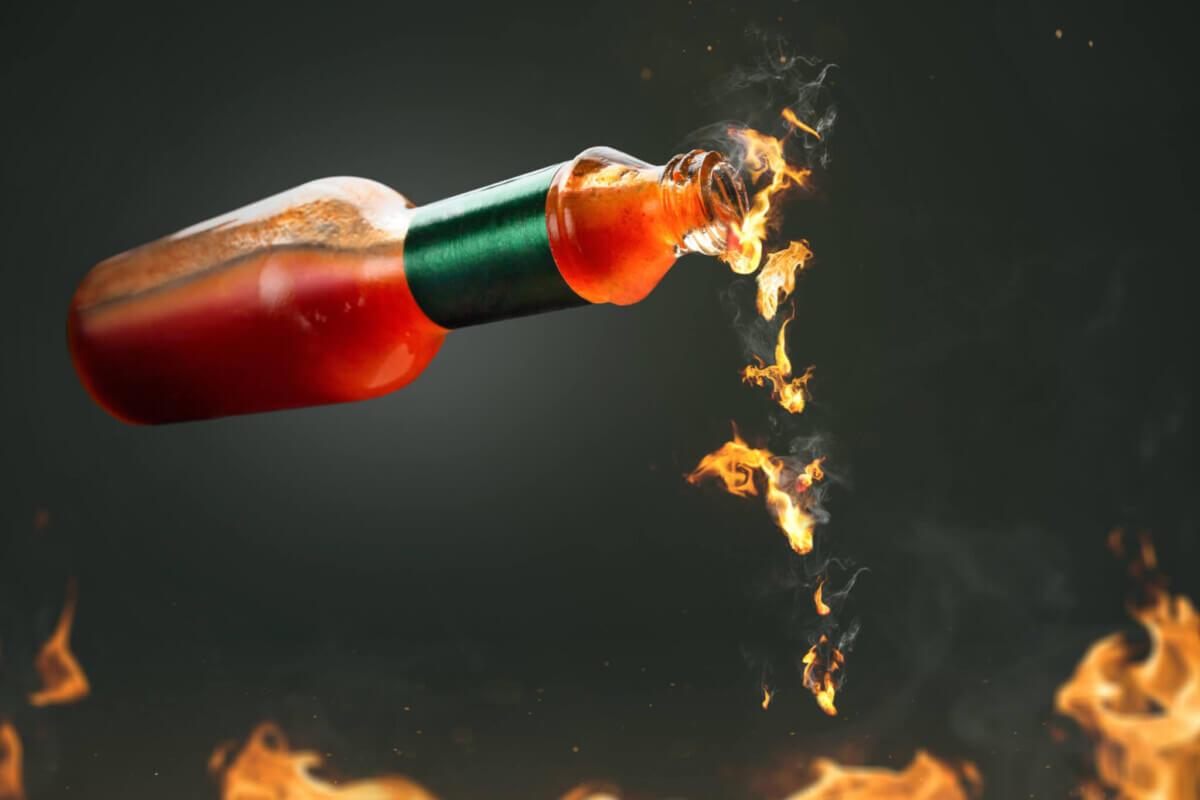 Hot sauce with fire droplets coming from bottle