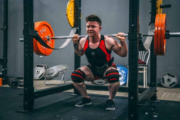 Man doing squat exercises using a barbell.
