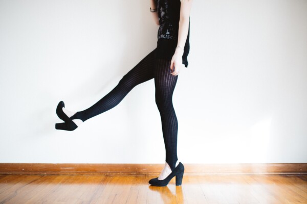 Woman in high heels doing walking with leg kicks