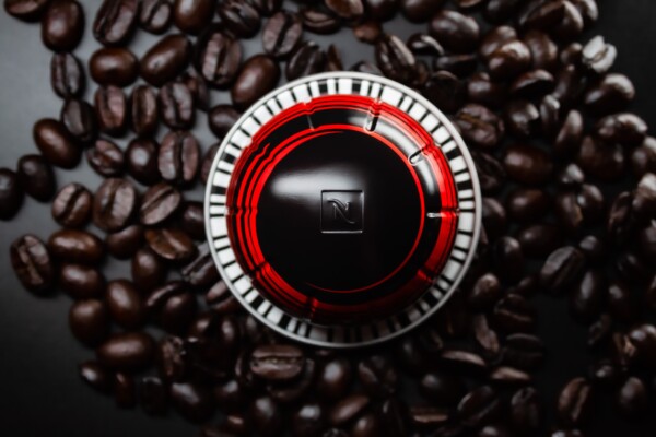 Pod for Nespresso coffee machine, sitting atop beans