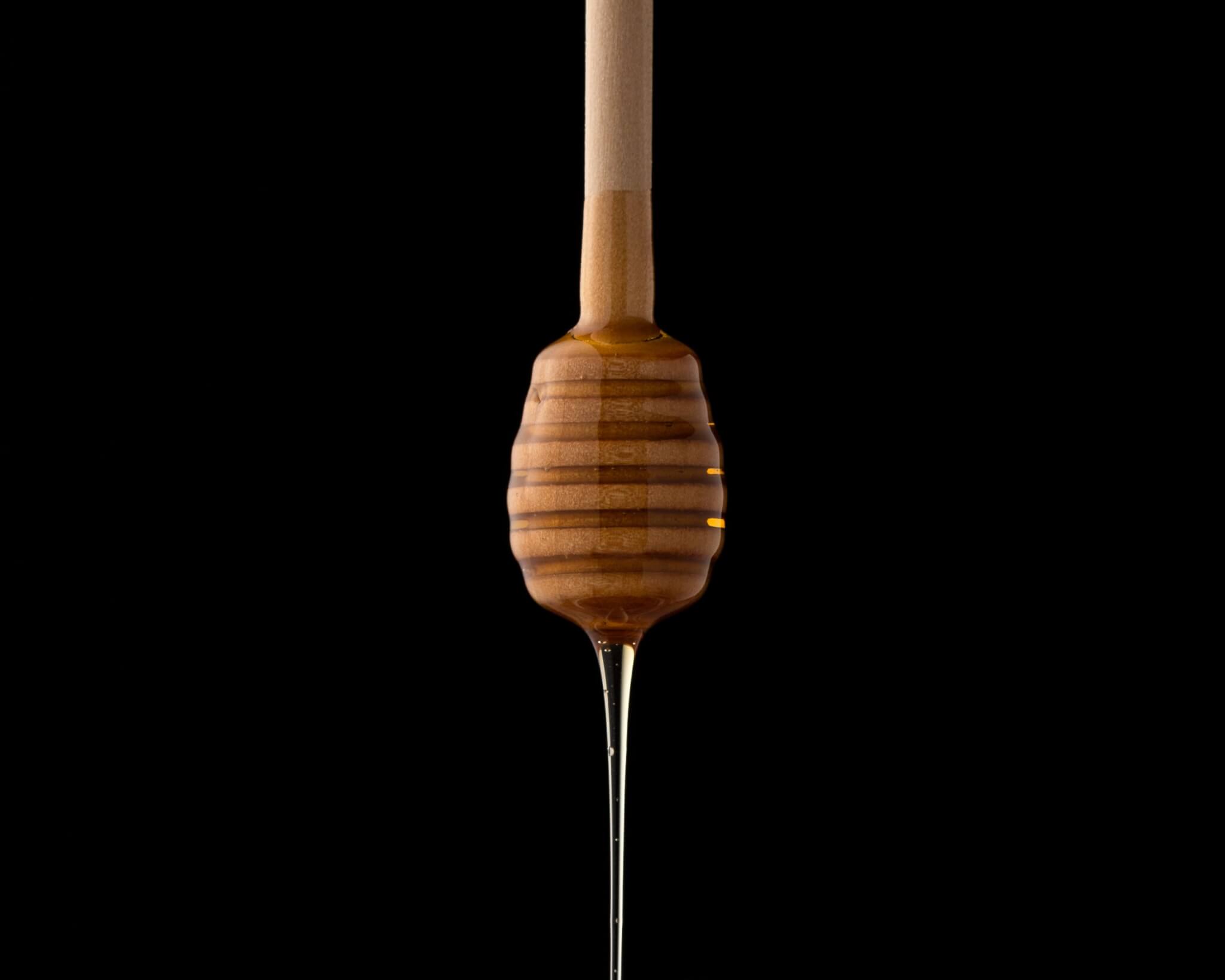 Honey oozing off a dipper.