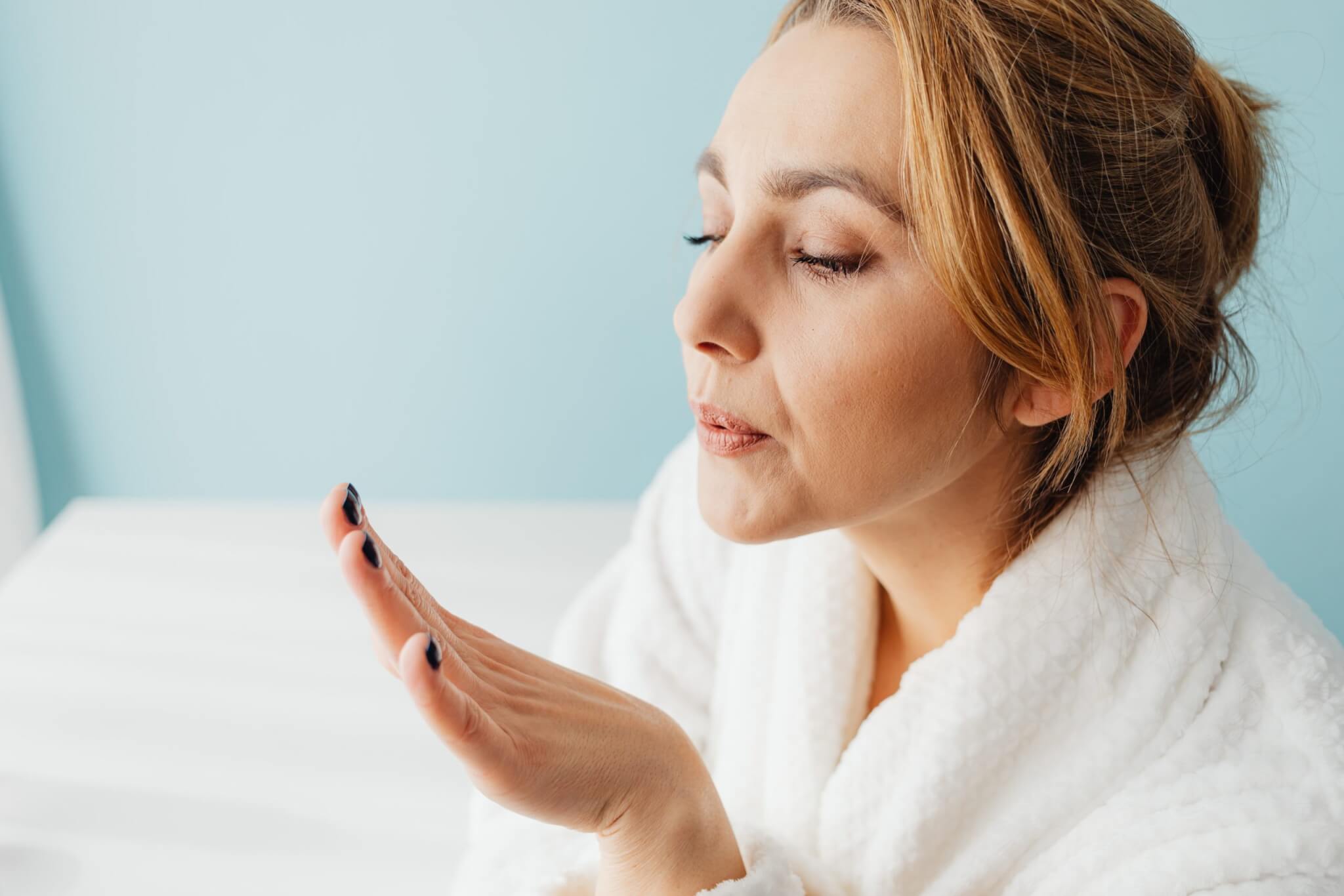 Woman blowing her fingernails dry after giving herself a manicure.