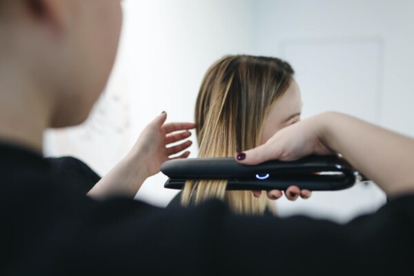 Stylist flat ironing a woman's hair