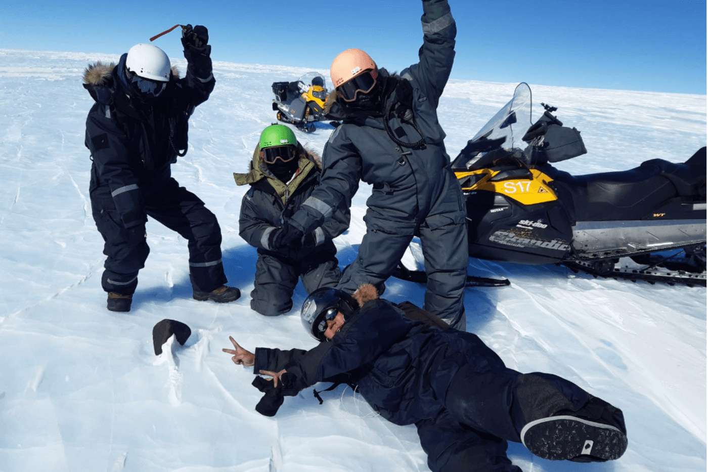 4 researchers pose with a meteorite in the snow