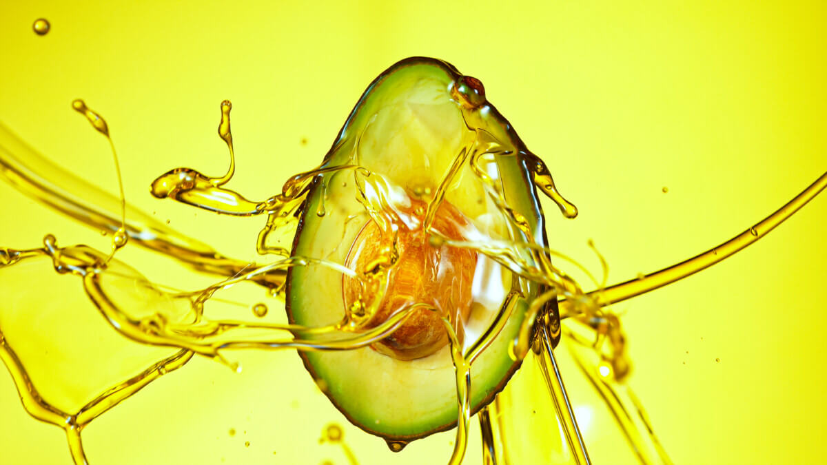 Avocado with oil splashing around it
