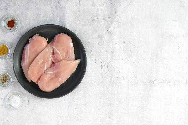 Chicken breasts in a skillet with a variety of spices