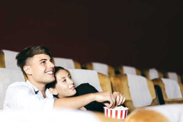 Couple watching a romance movie at the theater eating popcorn