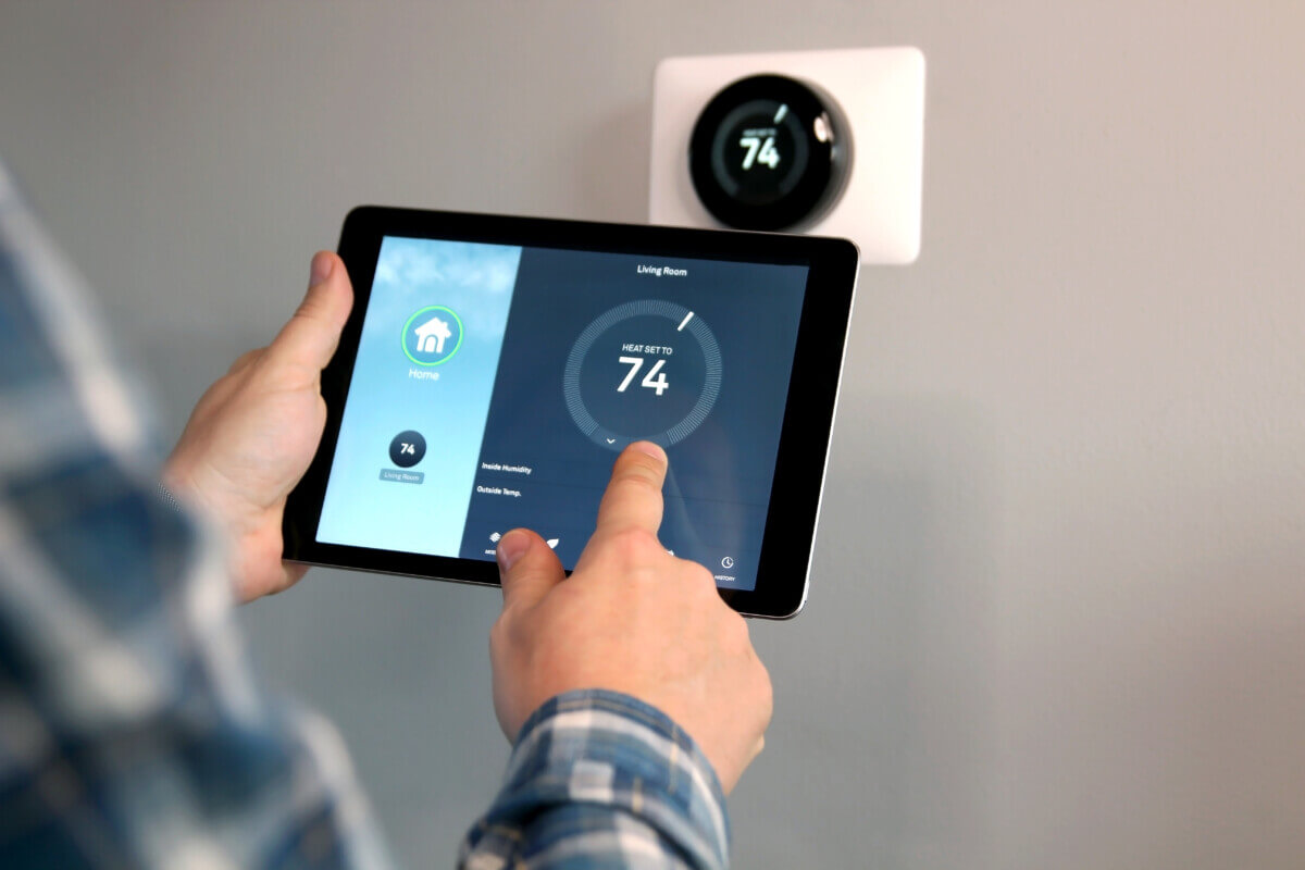 Man using a smart thermostat on his tablet