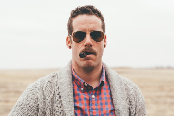 Man wearing Ray-Ban Aviator Sunglasses while smoking a cigar