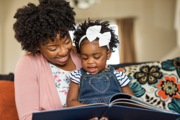 Woman reading a children's book to her young daughter