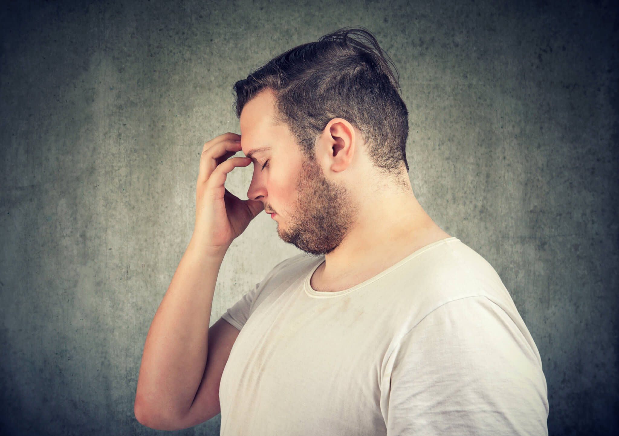 Overweight man with obesity stressed, tired, having a headache