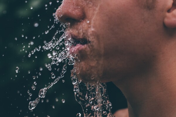 Drinking water splashing into a man's face
