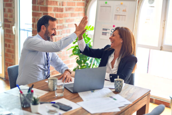 Colleagues high-fiving at the office