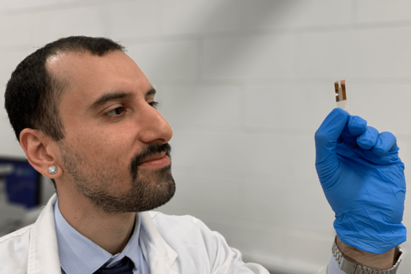 A male scientist holding a new type of mobile phone battery