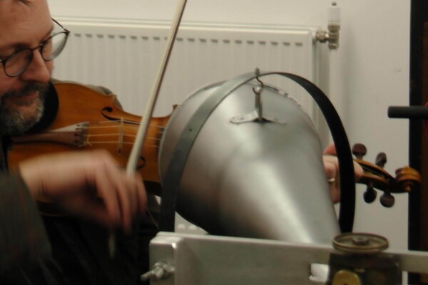 Musician playing the violin into sound equipment.