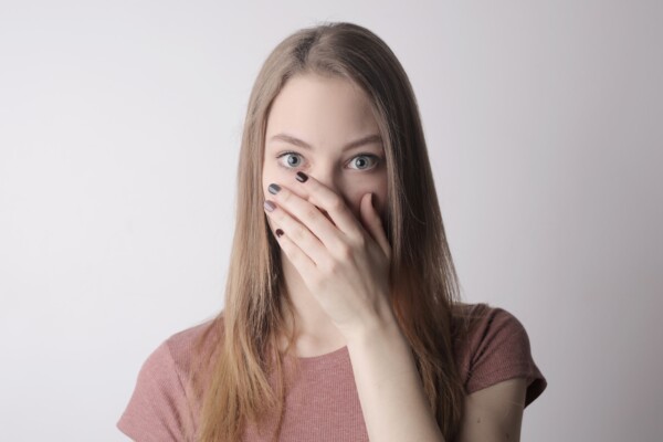 covering her mouth