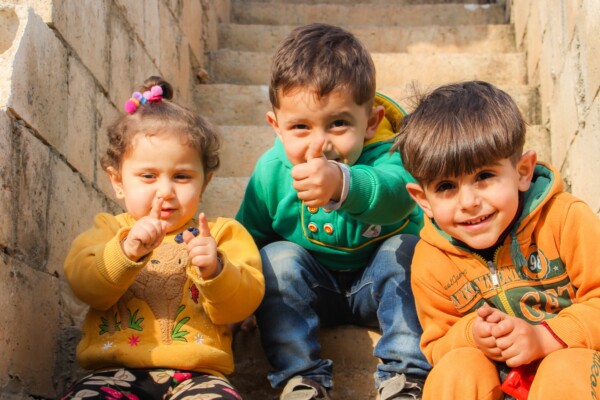 3 toddlers sit on a staircase