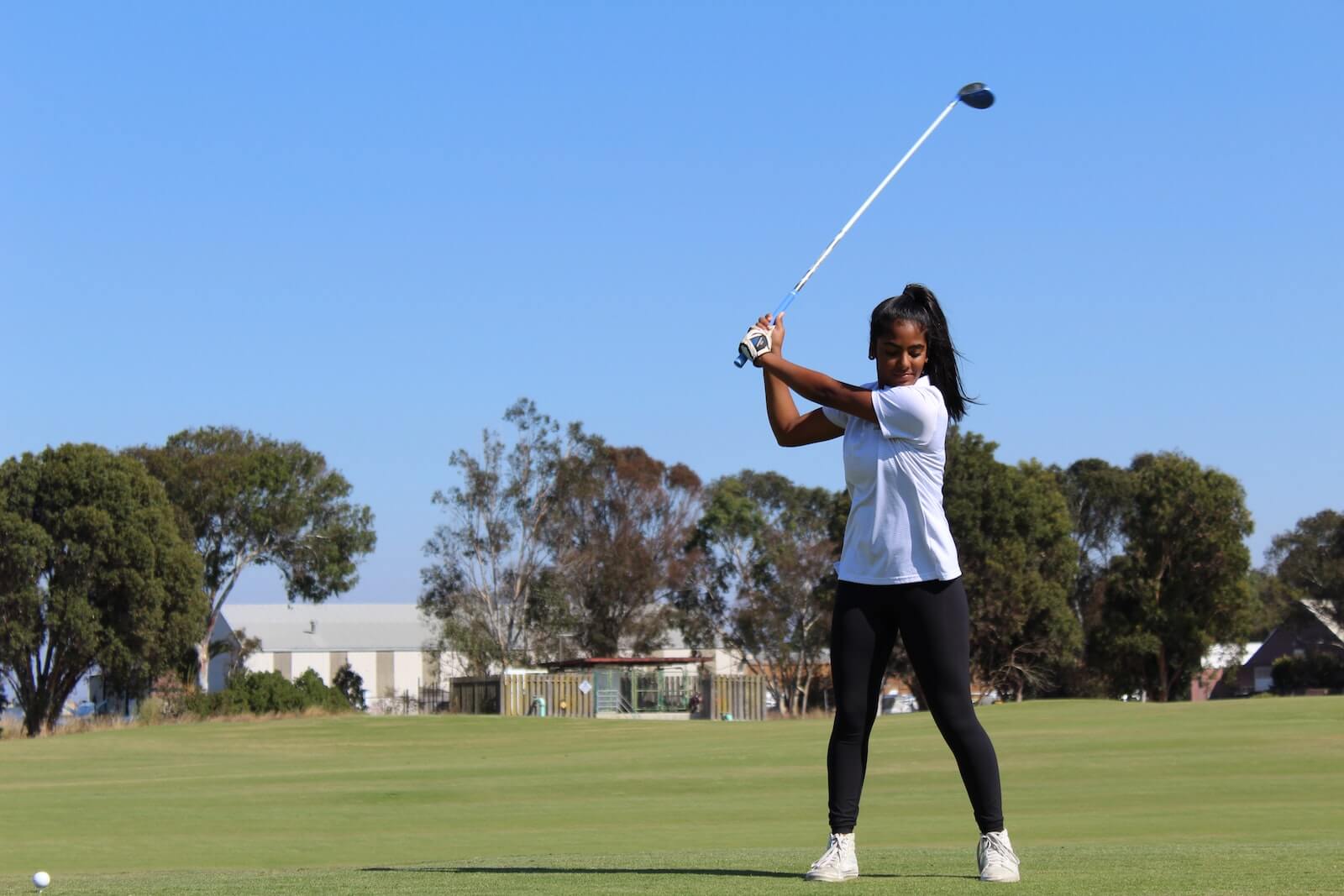 Woman playing golf, swinging her club