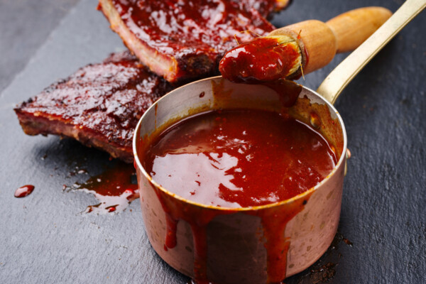 Hot and spicy barbecue sauce in a pot next to ribs