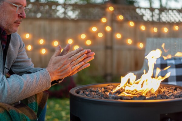 Man warming up out back next to a fire pit