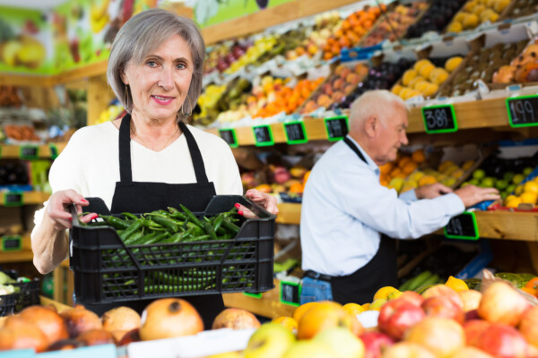 Senior woman and man working at a grocery store