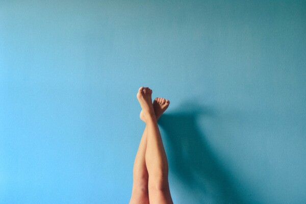 a woman's legs up on a blue wall