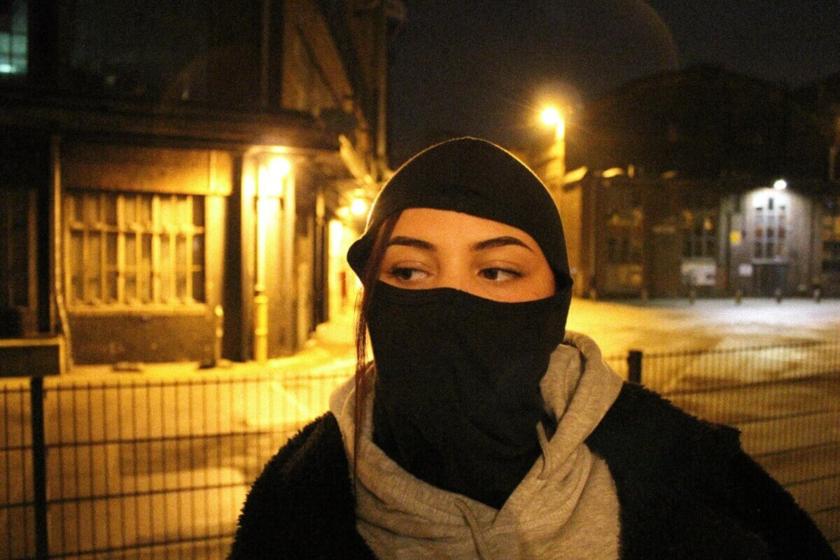 A woman wearing a ski mask at night