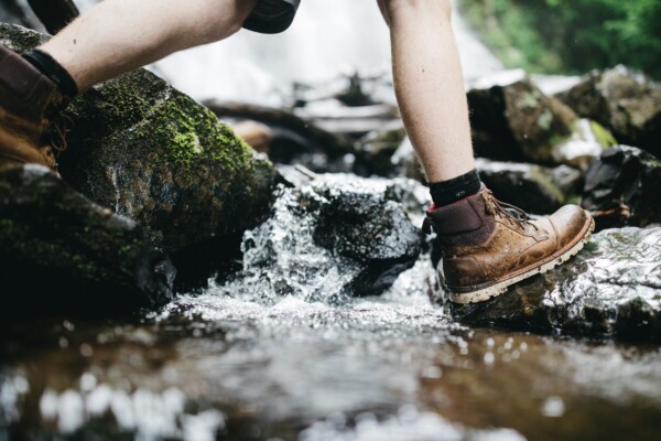 someone walking through a stream in hiking boots