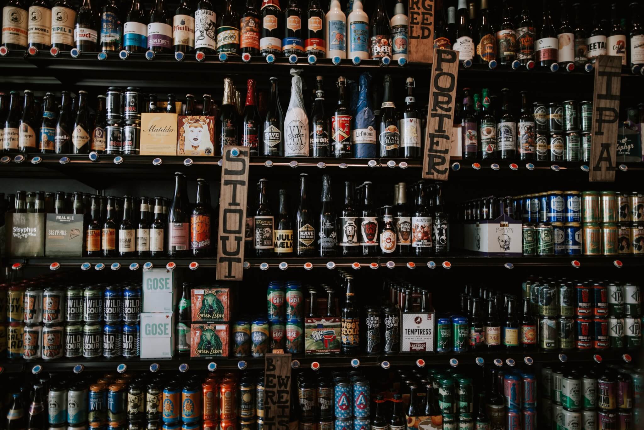 Beer cans and bottles lining the shelves of a store