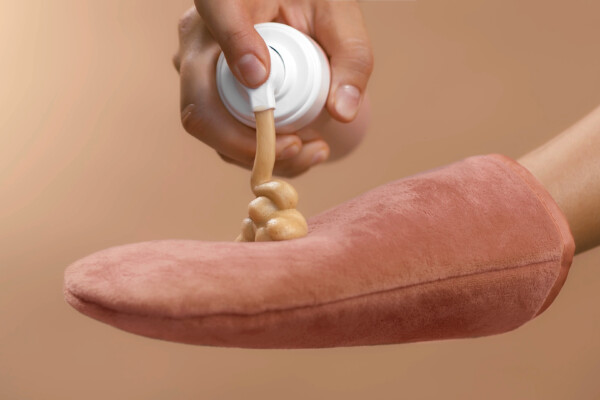 Person applying self-tanner tanning lotion