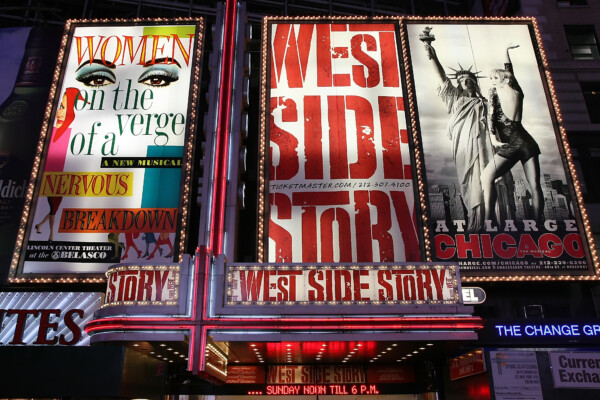 Theater at Times Square at 7th Avenue showing advertisement billboards for Broadway musicals, including West Side Story, in Manhattan