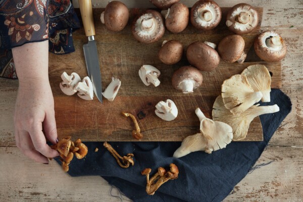 Woman cutting mushrooms on a cutting board