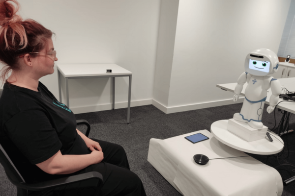 woman sitting with robot mental health coach