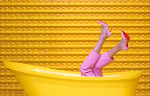 A woman wearing Louboutin's in a yellow bath tub