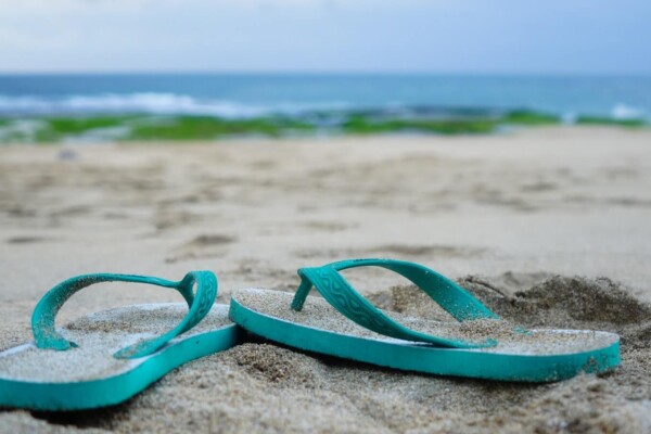 Flip flops on the beach in front of the ocean