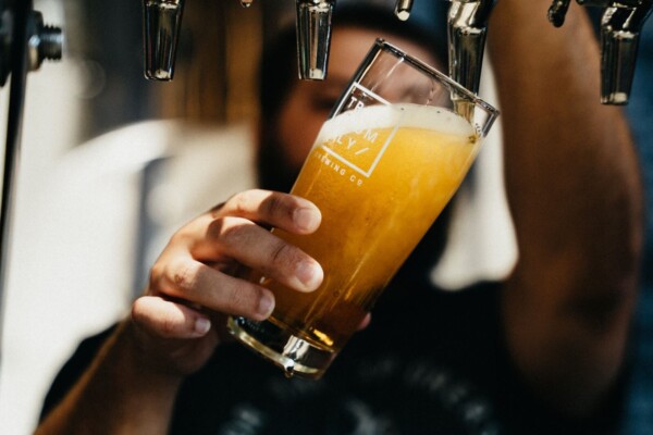 Someone filling up a beer by the tap