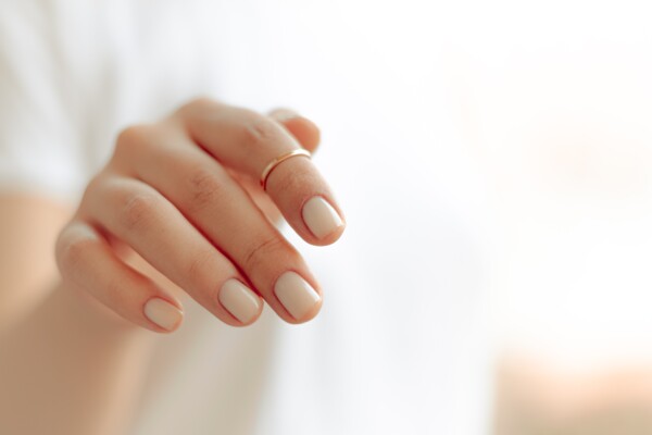 woman's hand with pale pink nail polish