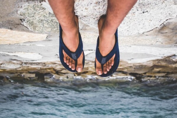 Someone wearing flip flops sitting on a cliff