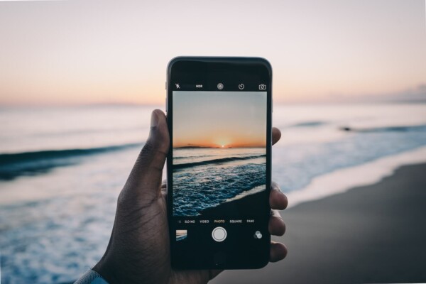 Person taking a picture of the beach on an iPhone