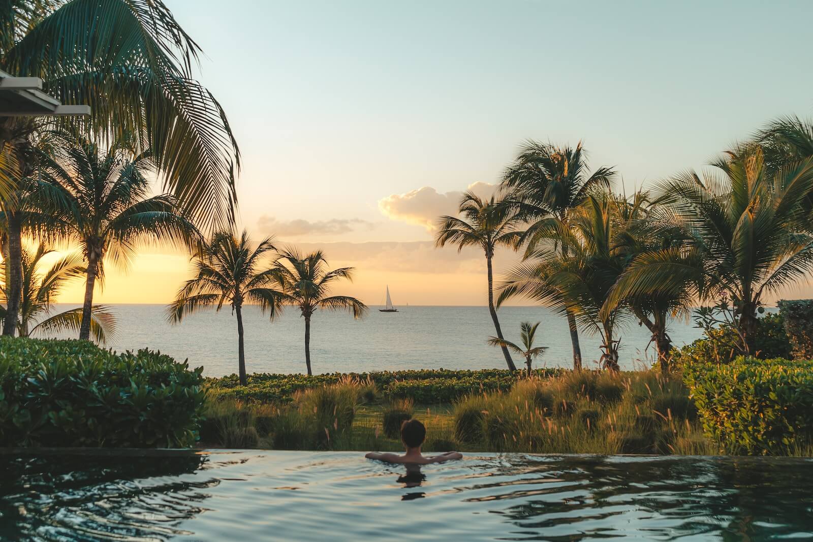 A person in an infinity pool overlooking the ocean in Anguilla